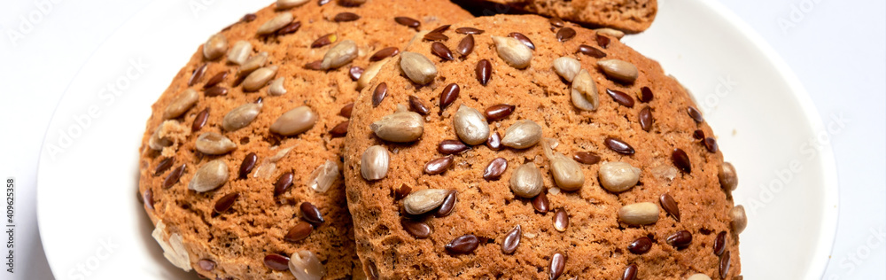 Banner of fresh oatmeal cookies, gingerbread on a light background. Oatmeal gingerbreads sprinkled with sunflower and flax grains close up Banner of fresh oatmeal cookies, gingerbread on a light background. Oatmeal gingerbreads sprinkled with sunflower and flax grains close up