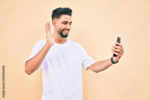 Young arab man smiling happy doing video call using smartphone at the city.