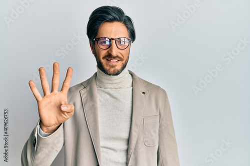 Young hispanic man wearing business jacket and glasses showing and pointing up with fingers number four while smiling confident and happy.