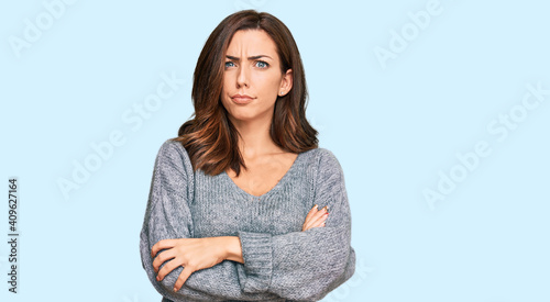 Obraz na plátně Young brunette woman wearing casual winter sweater skeptic and nervous, disapproving expression on face with crossed arms