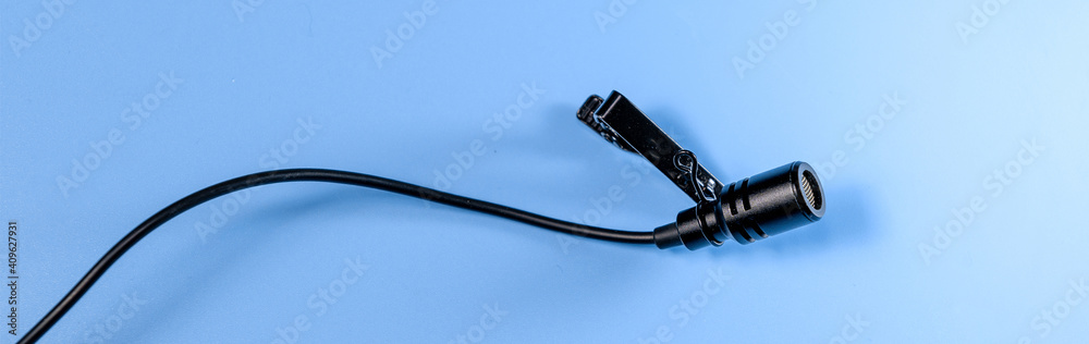 Banner of lavalier microphone on a blue background. Horizontal photo banner for website header design Banner of lavalier microphone on a blue background. Horizontal photo banner for website header design