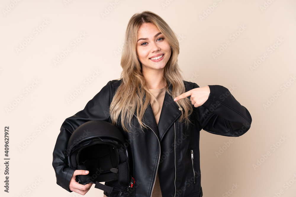 Russian girl with a motorcycle helmet isolated on beige background proud and self-satisfied Russian girl with a motorcycle helmet isolated on beige background proud and self-satisfied