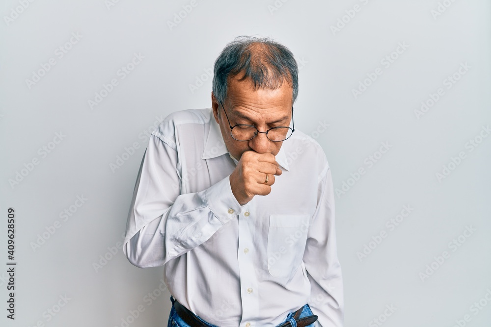 Middle age indian man wearing casual clothes and glasses feeling unwell and coughing as symptom for cold or bronchitis. health care concept. Middle age indian man wearing casual clothes and glasses feeling unwell and coughing as symptom for cold or bronchitis. health care concept.