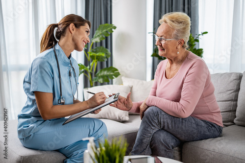 Female doctor supporting senior patient during home visit