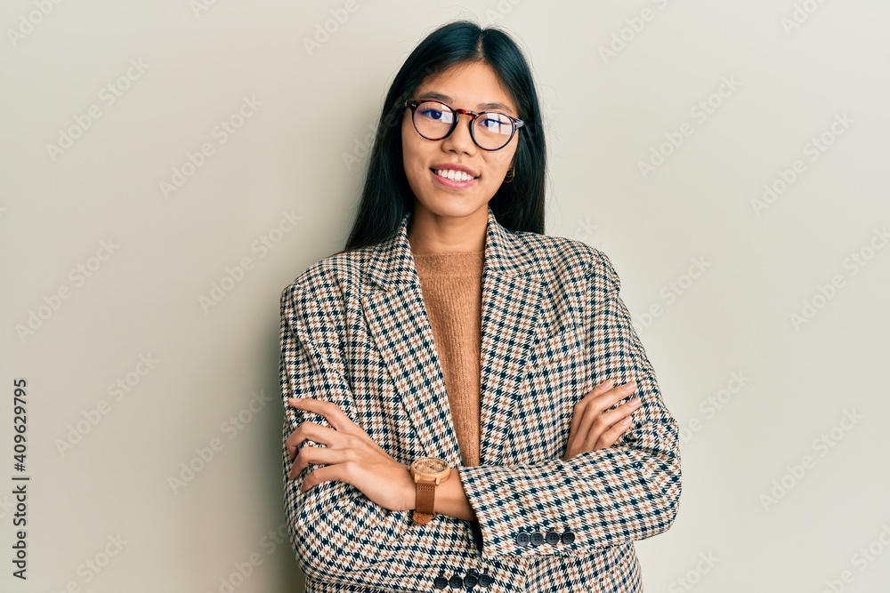 Young chinese woman wearing business style and glasses happy face smiling with crossed arms looking at the camera. positive person.