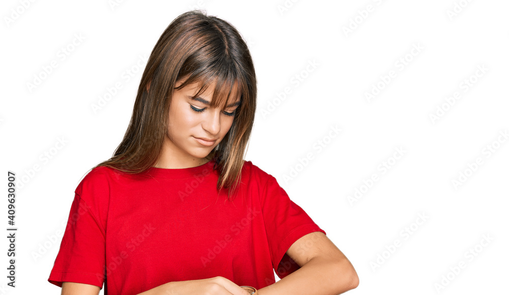 Teenager caucasian girl wearing casual red t shirt checking the time on wrist watch, relaxed and confident Teenager caucasian girl wearing casual red t shirt checking the time on wrist watch, relaxed and confident