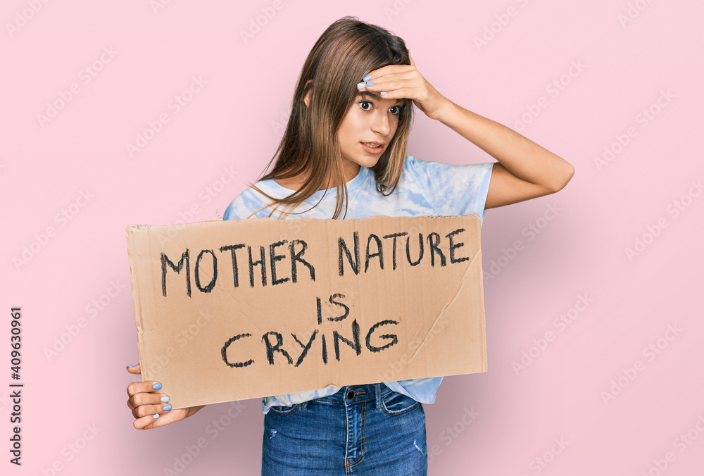 Teenager caucasian girl holding mother nature is crying protest cardboard banner stressed and frustrated with hand on head, surprised and angry face Teenager caucasian girl holding mother nature is crying protest cardboard banner stressed and frustrated with hand on head, surprised and angry face