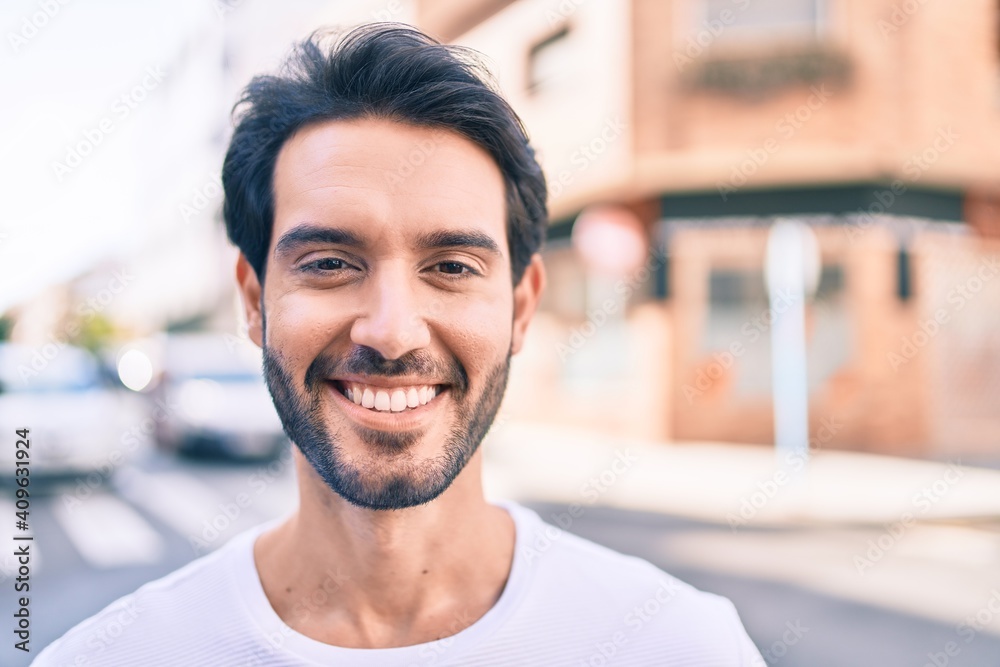 Young hispanic man smiling happy walking at the city. - obrazy, fototapety, plakaty 