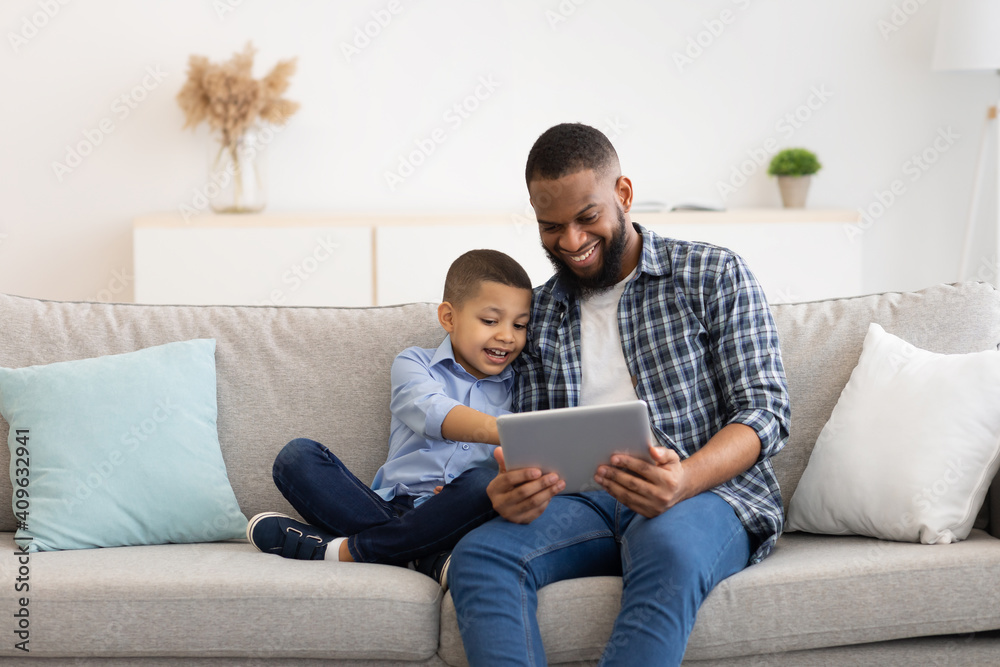 Young Black Father And Little Son Using Tablet At Home