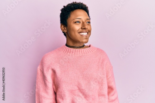 Young african american girl wearing casual clothes looking to side, relax profile pose with natural face and confident smile.