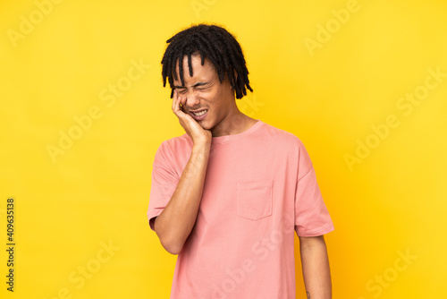Young african american man isolated on yellow background with toothache