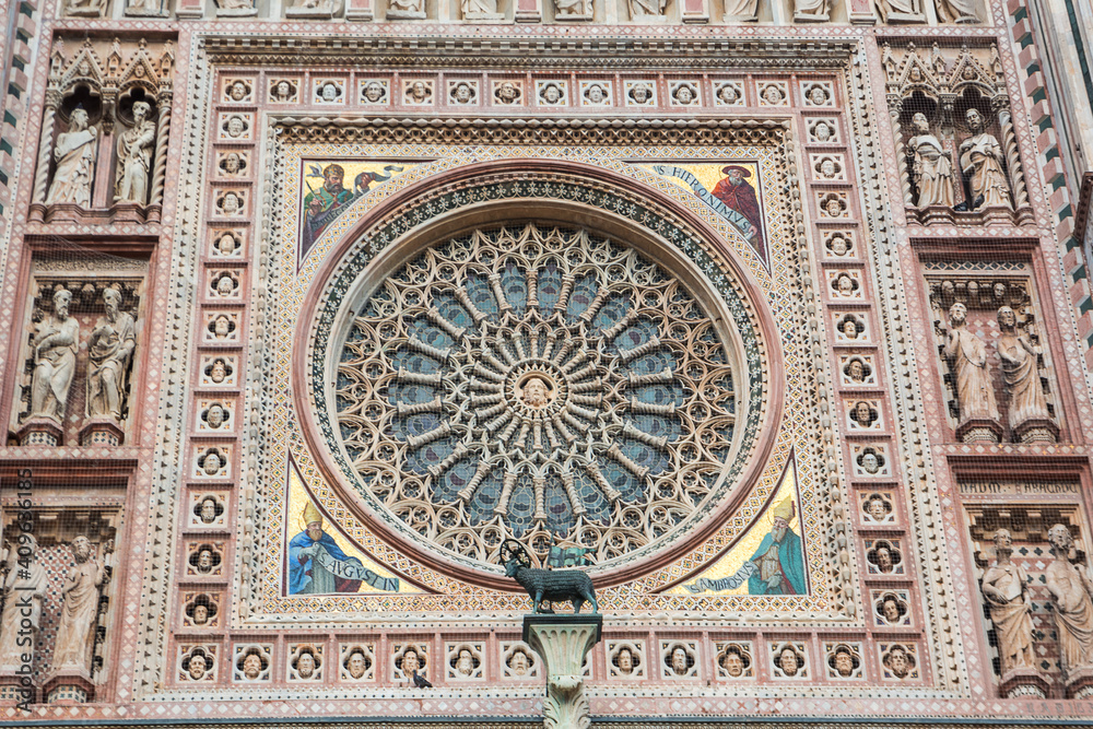 Detail of the facade of the Orvieto basilica with rose window, mosaics and statues