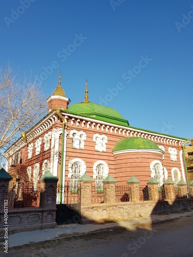 Red-brick Muslim mosque with green domes