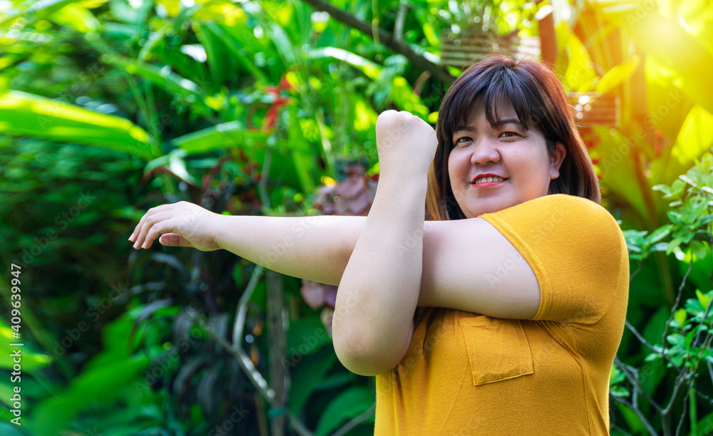 Healthy weight loss concept. Happy overweight young woman stretching before workout in the garden. Fat girl obesity stretch arm warm up before exercising in the morning at home. Healthy weight loss concept. Happy overweight young woman stretching before workout in the garden. Fat girl obesity stretch arm warm up before exercising in the morning at home.