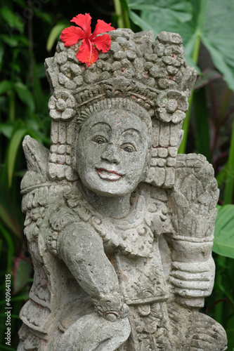 Indonesia Bali - Ubud Handmade Balinese stone statue with red Hibiscus flower