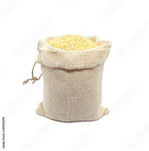 Millet in burlap sack isolated on white background. Raw yellow millets in a jute bag.