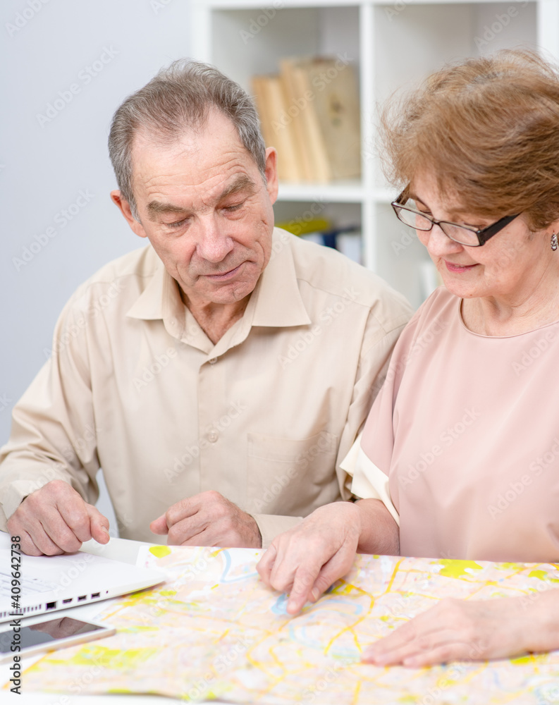 Senior couple look at map and plan holiday Senior couple look at map and plan holiday