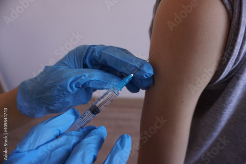 Vaccination of children from covid. Doctor injects vaccine in a patient's shoulder. Close up. For medical publications, immunization and vaccination campaign of people against infection