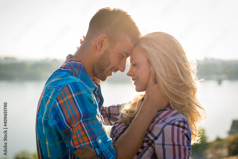 Emotional romantic couple in love smiling and enjoying beautiful day in nature at the beach. Young lovers touching Emotional romantic couple in love smiling and enjoying beautiful day in nature at the beach. Young lovers touching