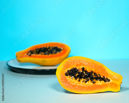 Two Half of Papaya with Seeds on Blue Background, Minimalism Trendy Food, Healthy and Detox Eating, Raw lunch, Copyspace, Exotic Fruit