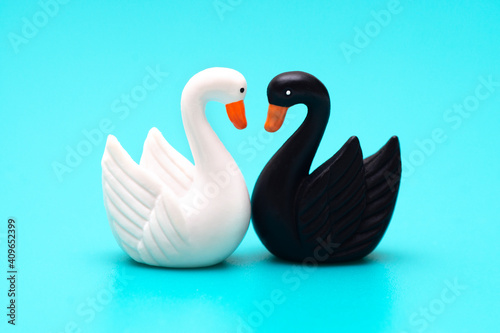 Fototapeta Naklejka Na Ścianę i Meble -  Two toy swans black and white on a blue background