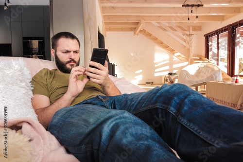 man with a smart phone sits in comfy chair