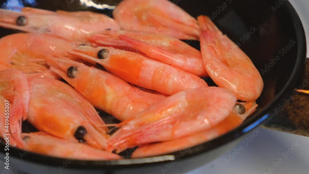 Cooking seafood. Frying shrimps, turning to the other side for frying in a pan in 4K Cooking seafood. Frying shrimps, turning to the other side for frying in a pan in 4K