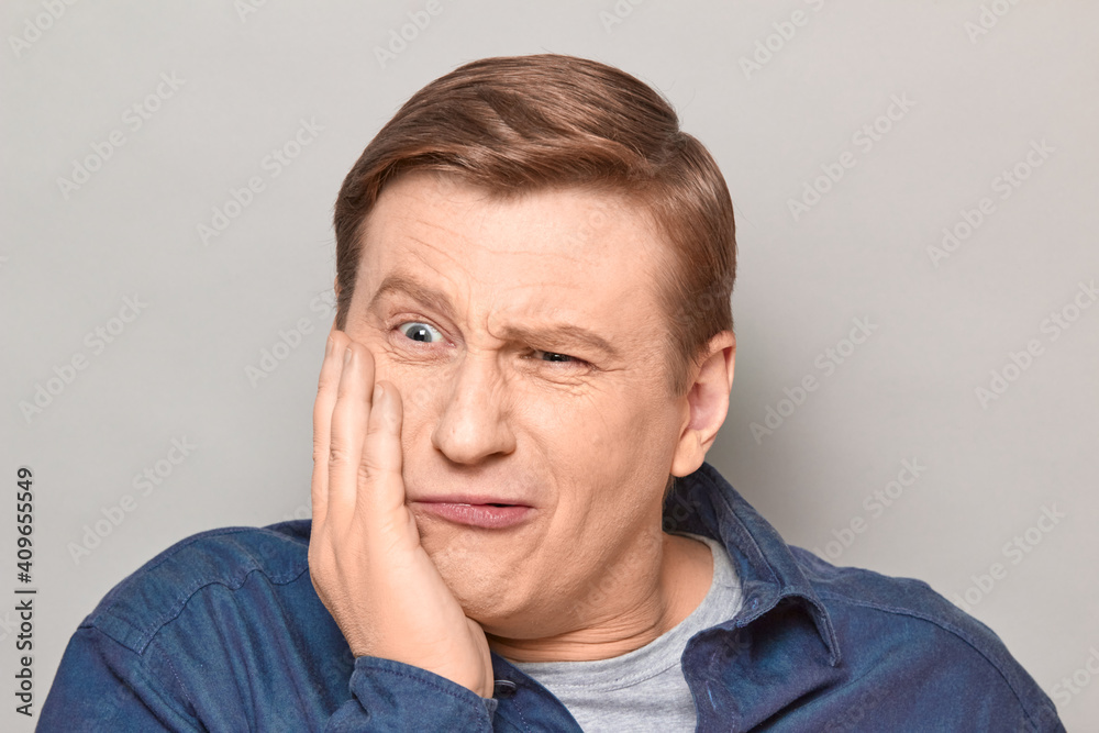 Portrait of unhappy man touching cheek and suffering from toothache Portrait of unhappy man touching cheek and suffering from toothache
