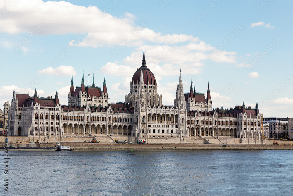 The magnificent building of the Hungarian Parliament on the Danube River embankment. Summer sunny day. Budapest, Hungary.
