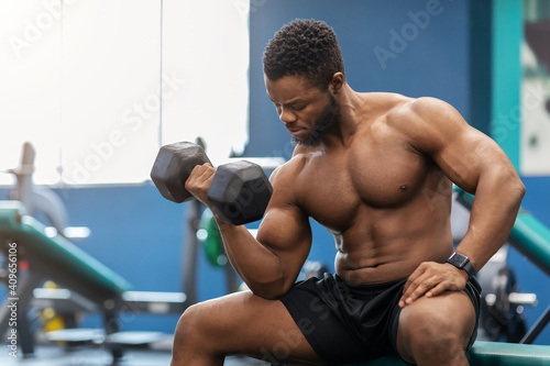 Handsome african american muscular man exercising with barbell