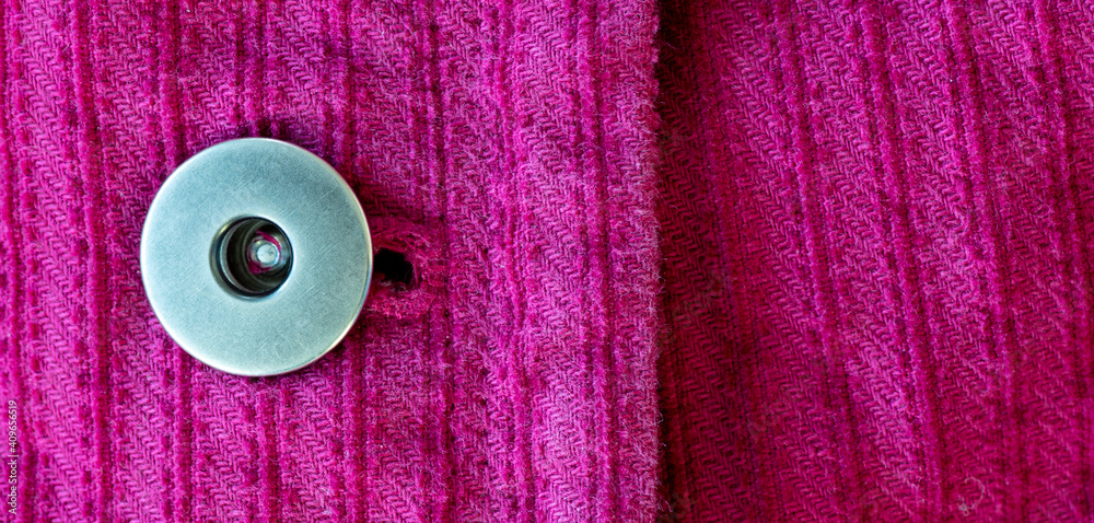 Macro view of silver metal button and woven pink fabric Macro view of silver metal button and woven pink fabric