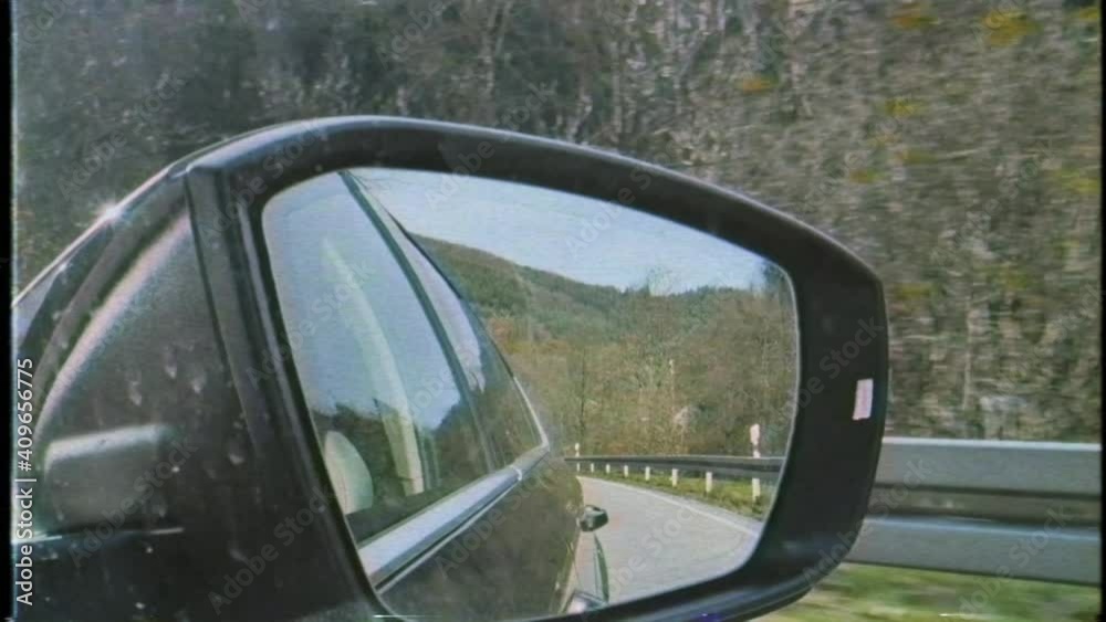 POV at the rear view car mirror with VHS vintage tape effect - German Black forest in the background
POV at the rear view car mirror with VHS vintage tape effect - German Black forest in the background