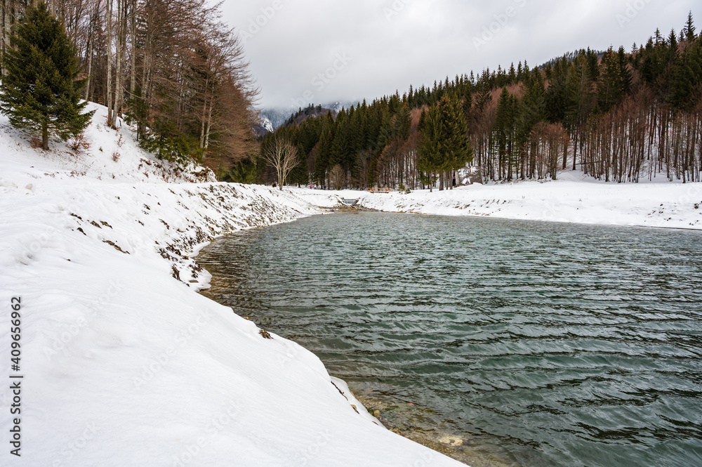 River in snowy mountain landscape in Romanian Carpathians during winter