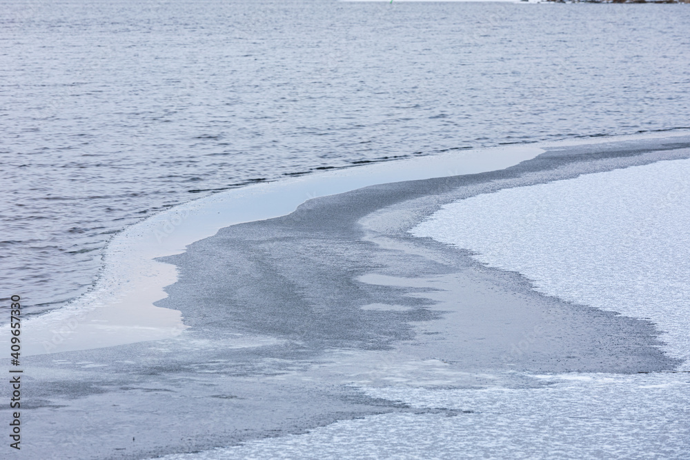 Partially frozen lake surface and snow