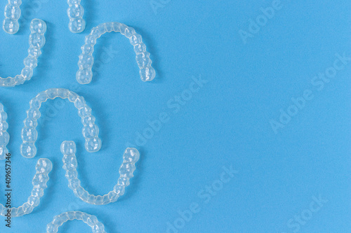 Invisalign braces or invisible retainer on blue background photo
