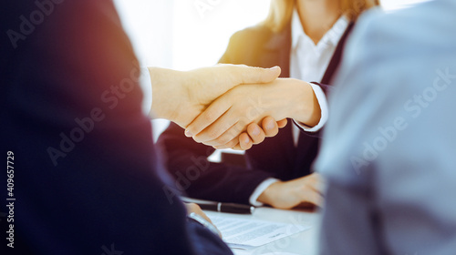 Businesspeople or lawyers shaking hands finishing up meeting or negotiation in sunny office. Business handshake and partnership