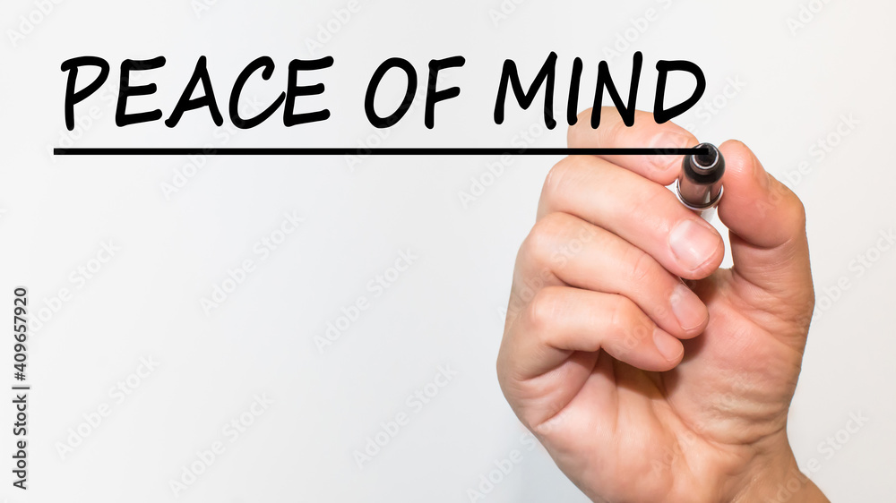 the hand writes text PEACE OF MIND with a marker on a white background. business concept the hand writes text PEACE OF MIND with a marker on a white background. business concept