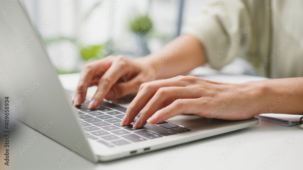 Freelance young Asia businesswoman casual wear using laptop working in living room at home. Working from home, remotely work, self isolation, social distancing, quarantine for corona virus prevention.