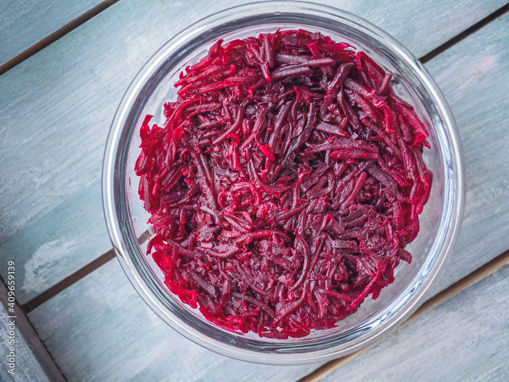 Fototapeta premium Boiled grated beetroot in a glass round container top view