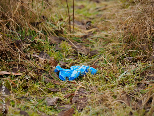 discarded rubber latex gloves in the grass light frost covering covid 19 protection