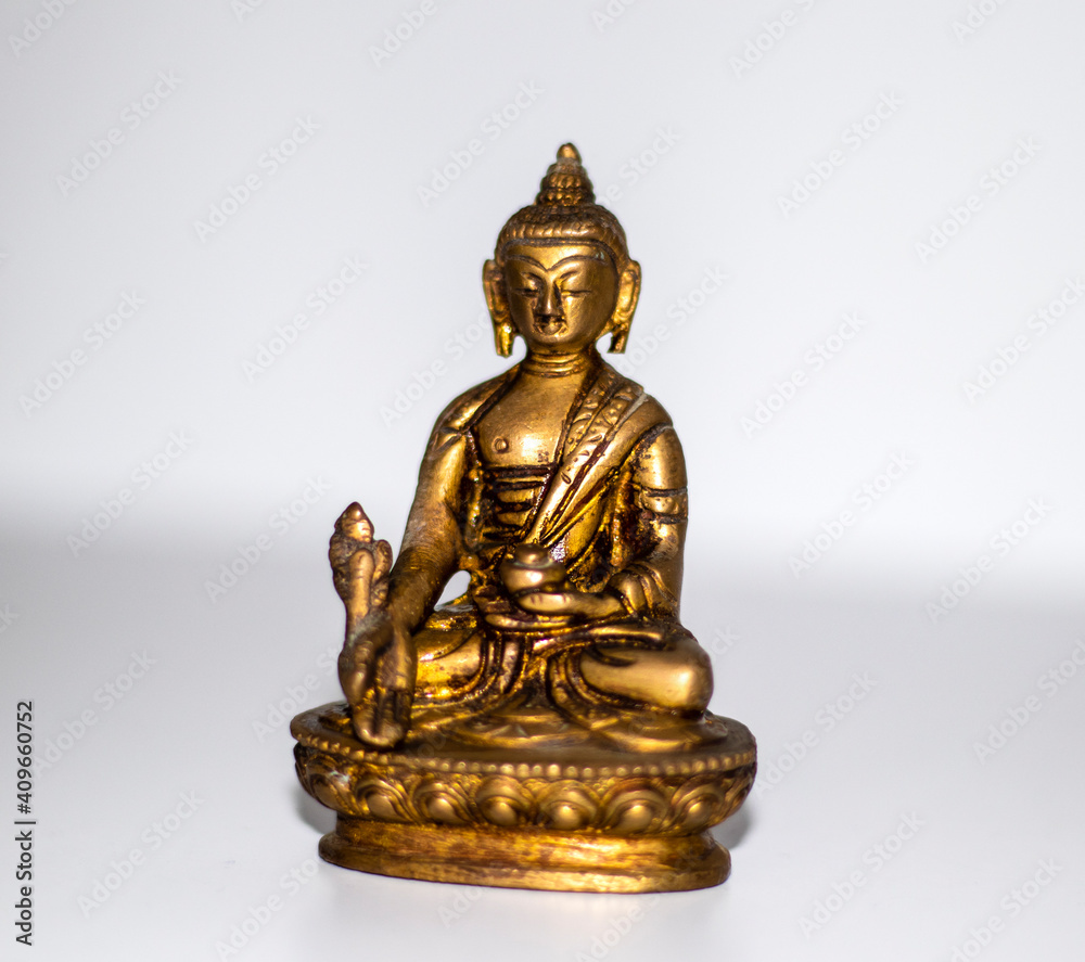 Close up shot of a bronze buddha mini statue. Indoors