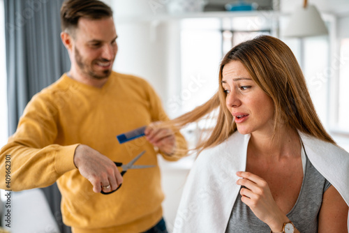 Man makes haircut to woman at home during quarantine.