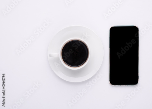 cup of coffee and phone on white background
