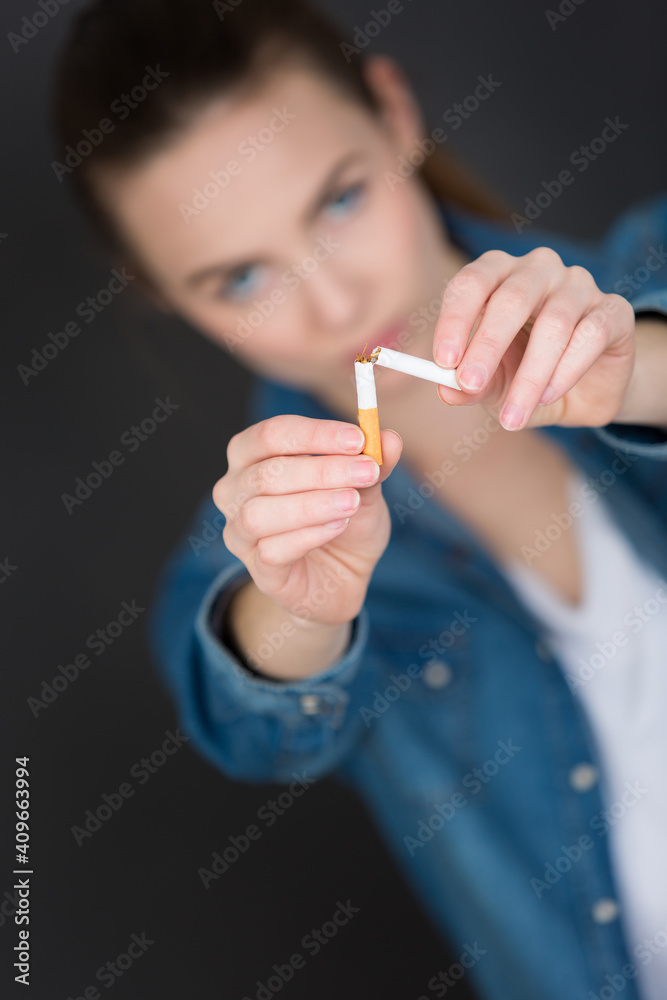 Obraz premium a girl is breaking cigarette
