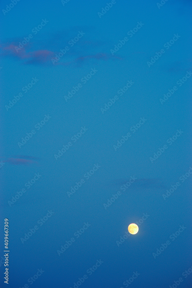 full red moon rising on blue sky background full red moon rising on blue sky background