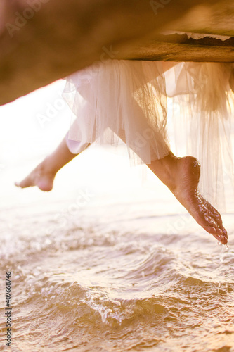 The girl flaps her feet in the sea
