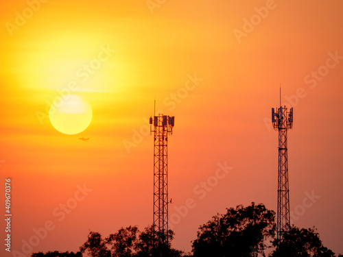 Billede på lærred communication transmission towers by silhouette of twilight sky with sun the dig