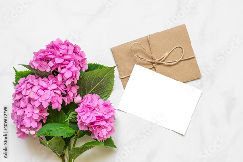 Blank greeting card with pink hydrangea flowers bouquet on white background. mock up. flat lay. top view