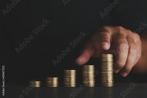 touch your coins and financial costs wisely and prudently investing and saving Dark tone style on black background The concept of success from investing to increase future profit. photo