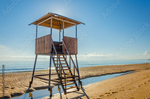 Lifeguard tower on an empty sandy beach.